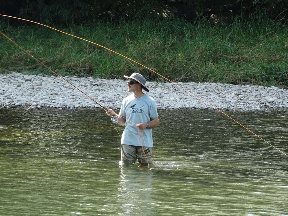 fisherman wading while fly fishing