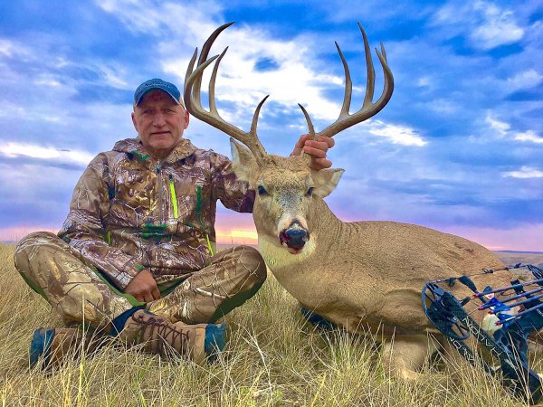 hunter kneeling beside deer