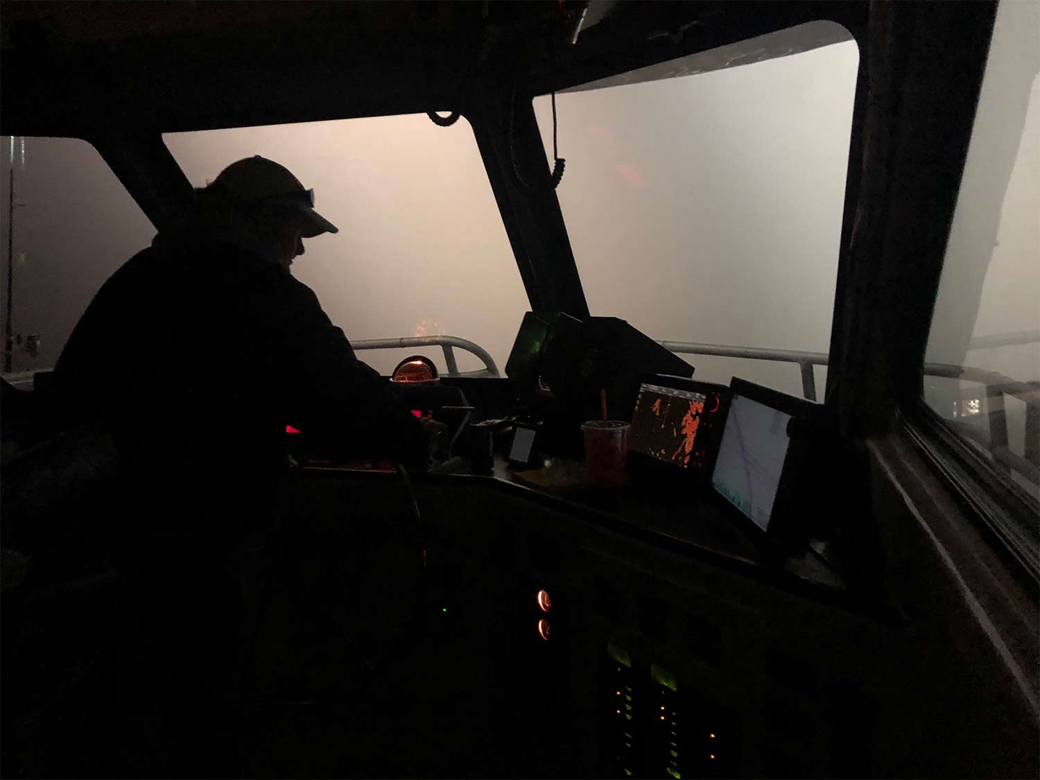 boat captain navigating boat through fog