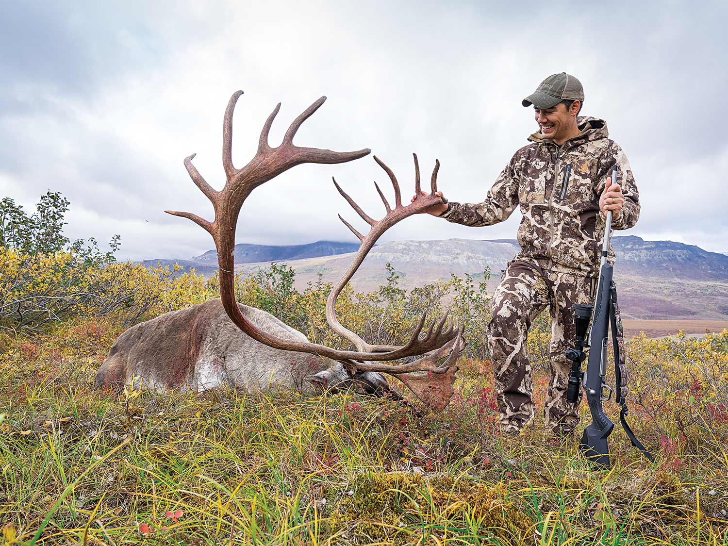 Alex Robinson standing by an alaskan caribou