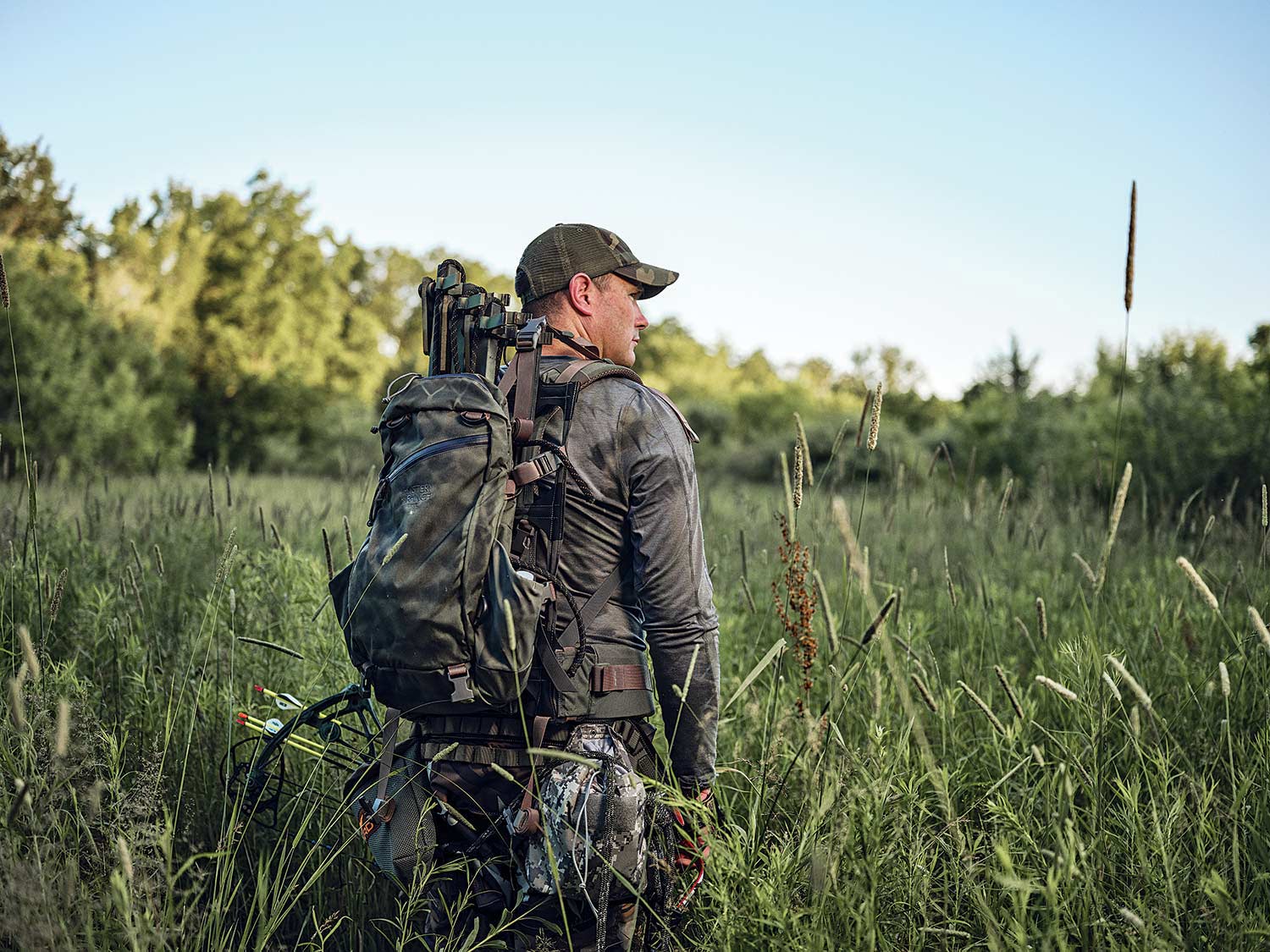 bow hunter walking through a field