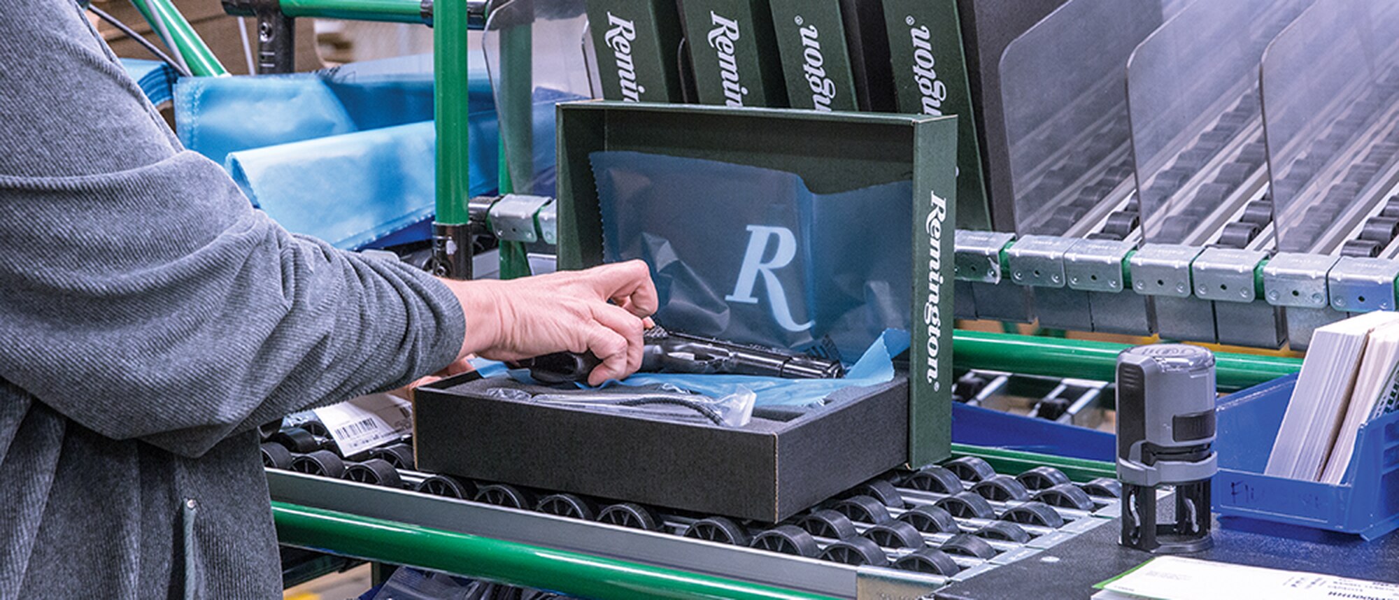 An R-1911 semi-auto handgun is boxed and prepared for shipment