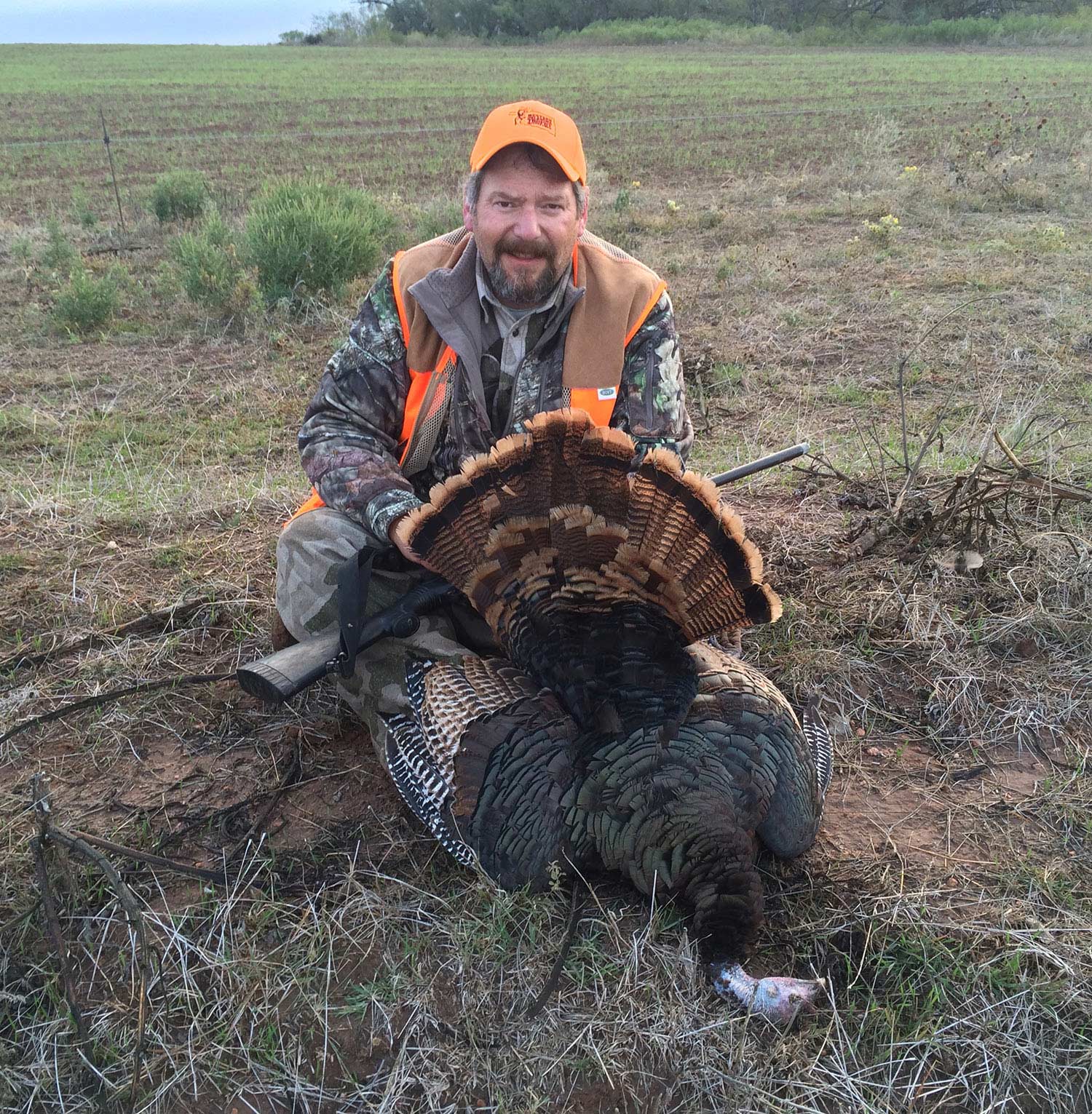 hunter kneeling behind a turkey