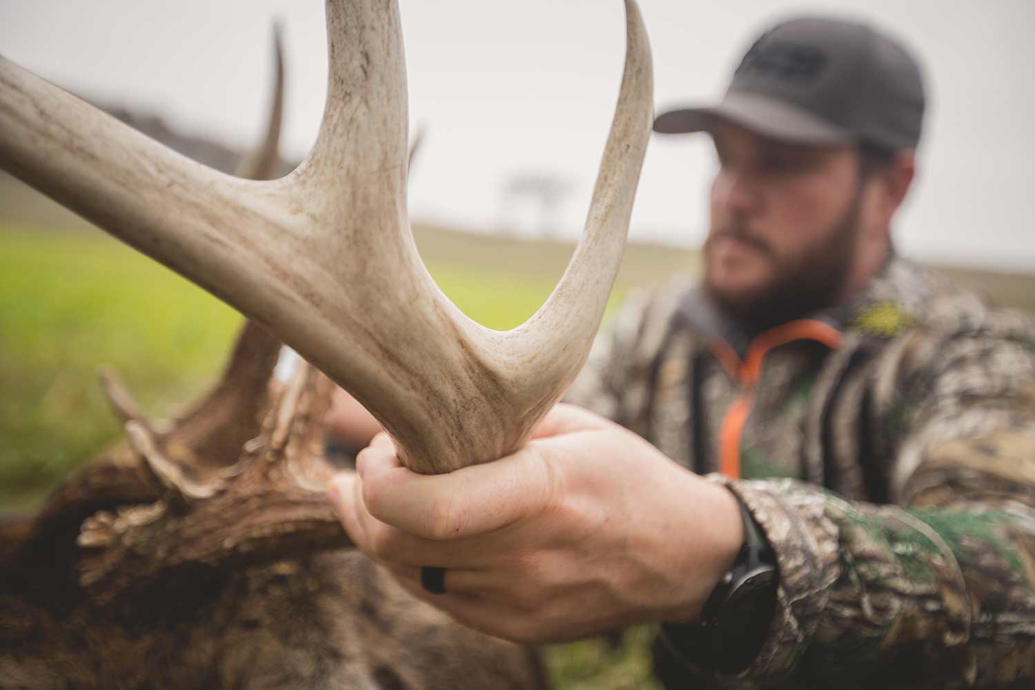 Hunter holding up trophy antlers of a buck.