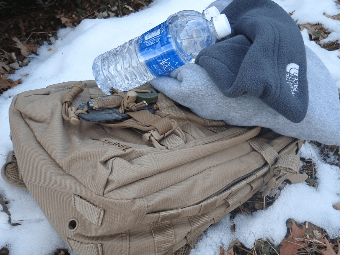 winter survival gear and water in the snow.