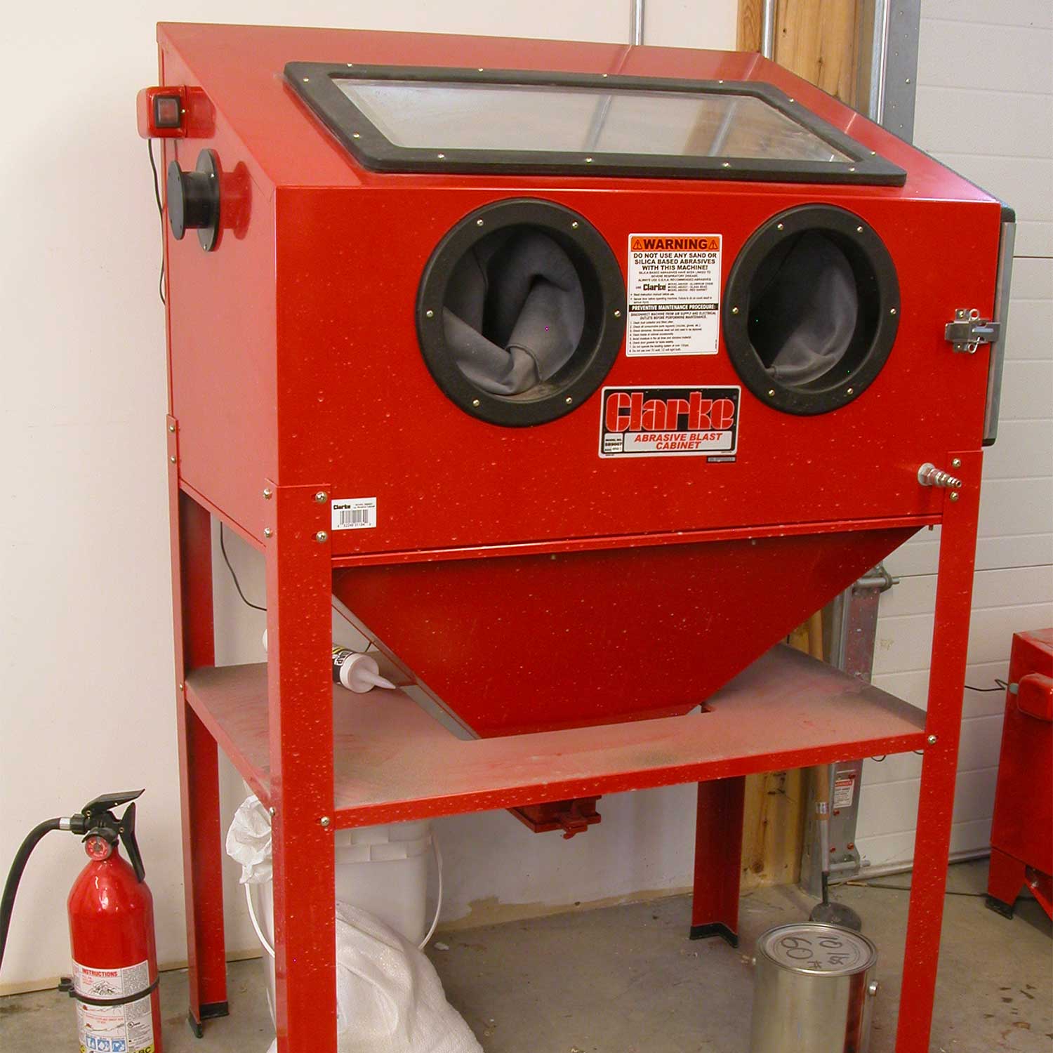 A large red sandblasting cabinet.