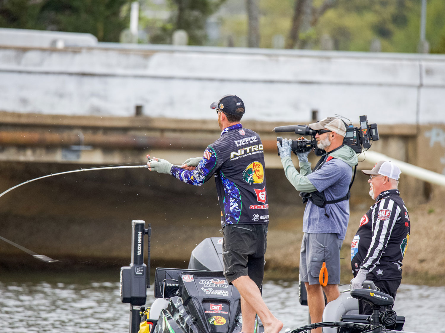 Angler Ott Defoe fishing while a camera crew films.