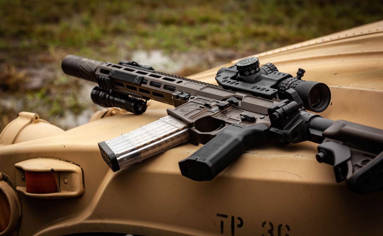 A Lone-Star TX15 AR-15 Rifle on the hood of a tan utility vehicle.