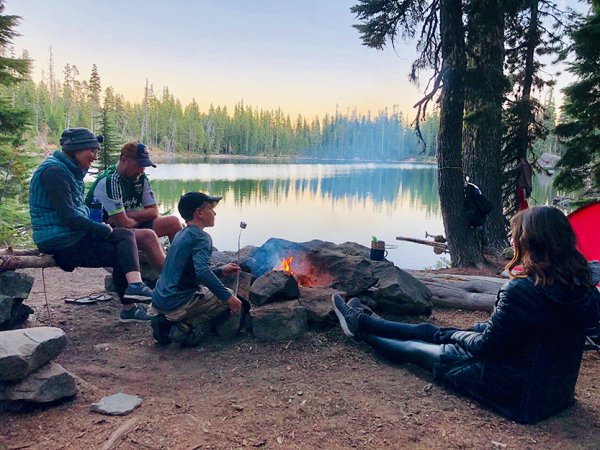 family sitting near fire