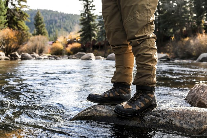 person near stream in boots