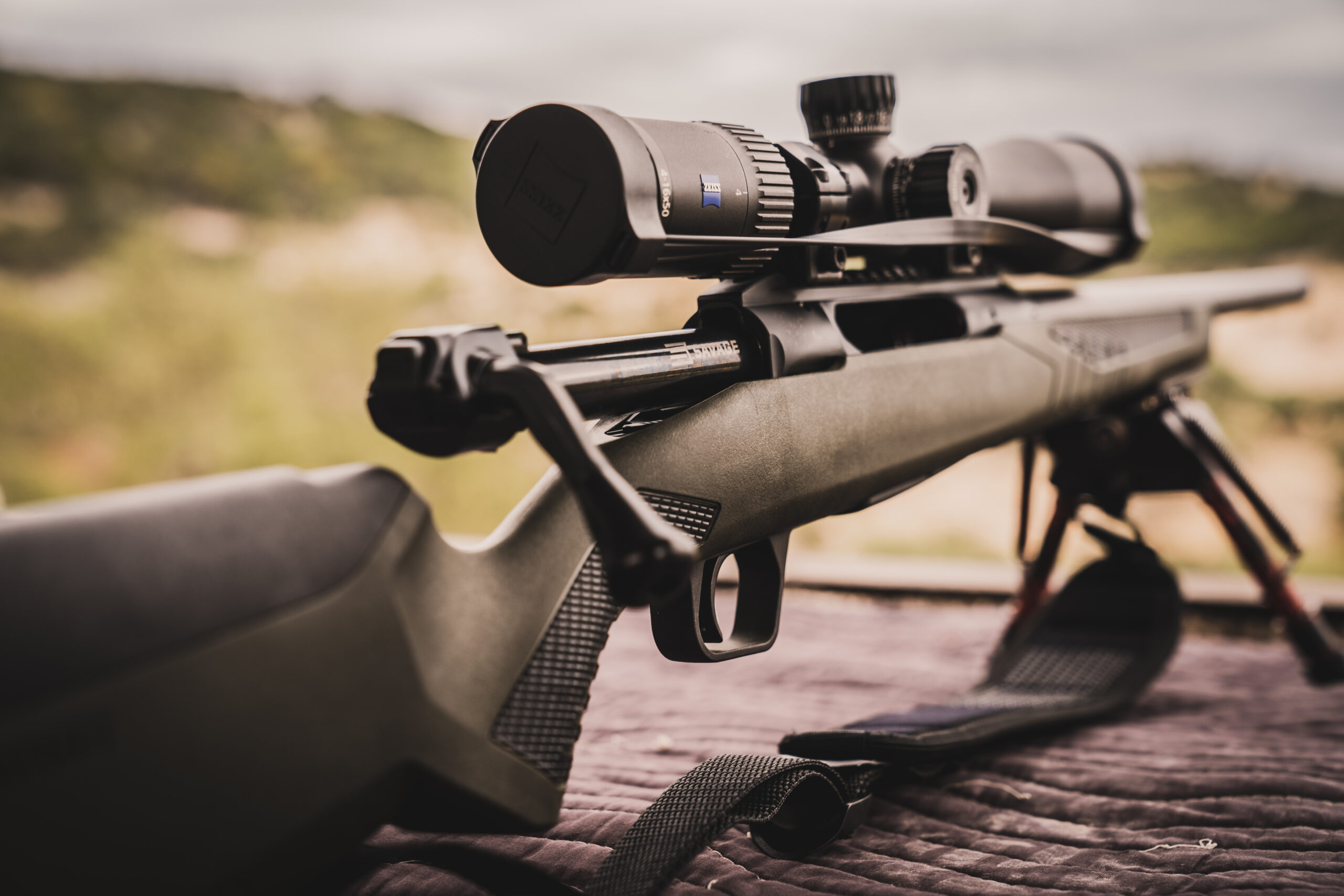 A green straight-pull bolt-action rifle resting on a shooting bench at FTW Ranch.