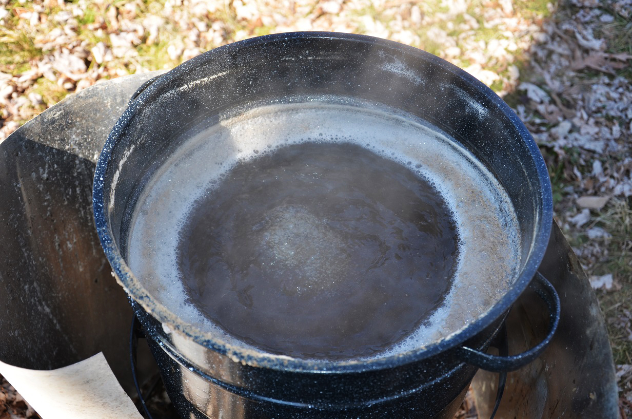 Large cast iron pot being used to reduce sugar maple sap to maple