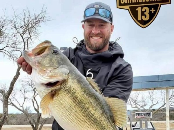 An angler holds up a largemouth bass.