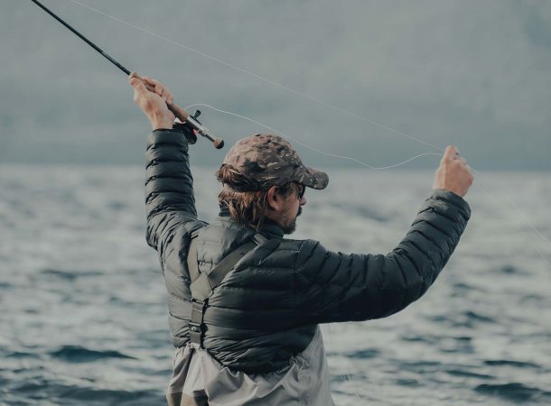 A man prepares to cast a fishing line in the water.