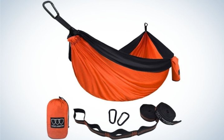  An orange and black single parachute hammock with a bag and other items for hammock.