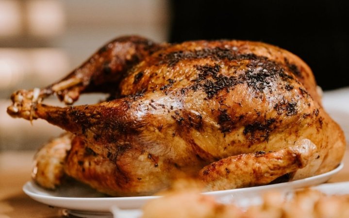 A roasted chicken on a white ceramic plate photo.