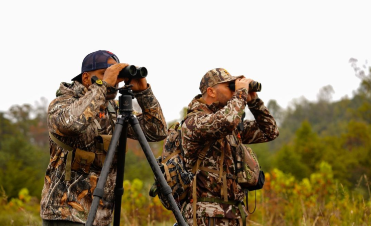 Bowhunters glassing through binoculars.