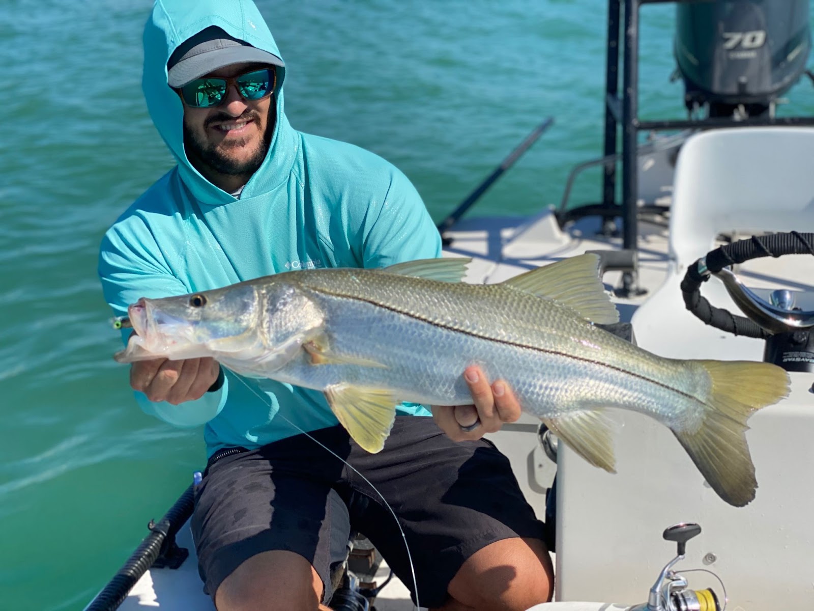 fisherman holding snook with Shimano Stradic FL spinning reel