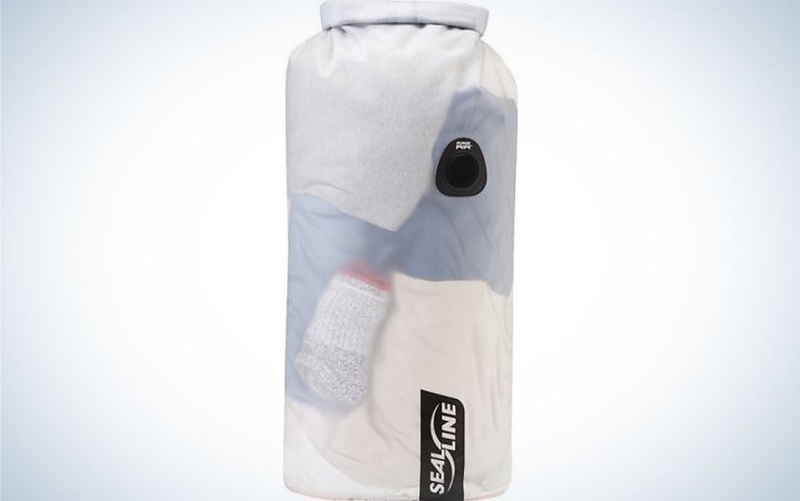  A large bag similar to a boxing bag which is white with water shades as well as with two black stripes and in the shape of a cylinder.