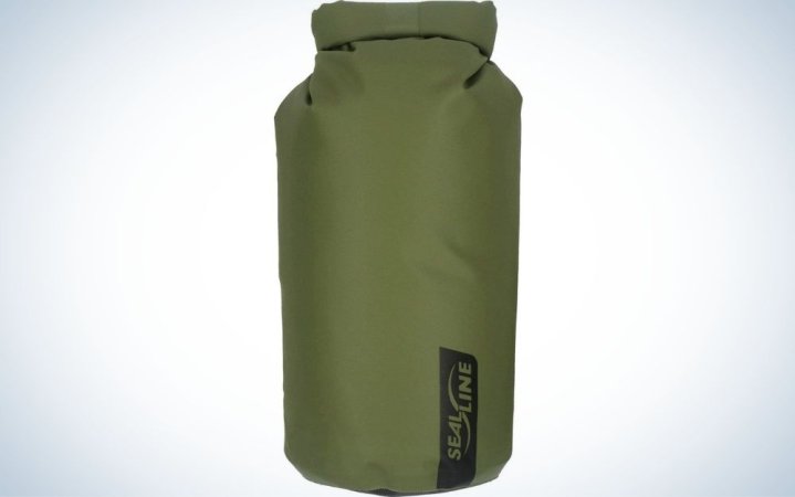  A large bag similar to a boxing bag which is green and in the shape of a cylinder.