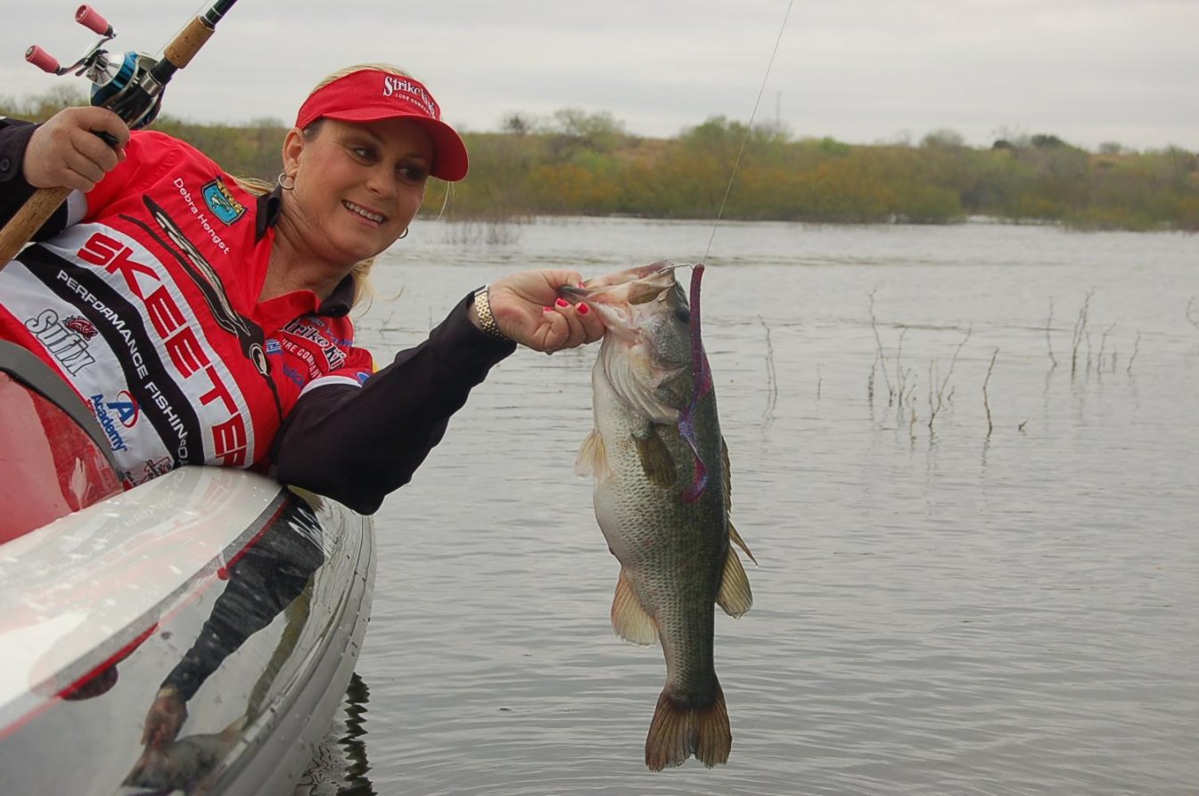 An angler catches a bass off a boat