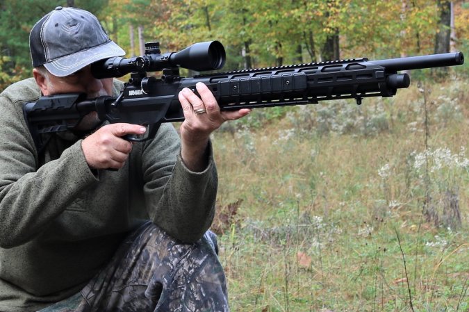 A man preparing to shoot a black air rifle