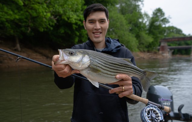 A man holding a fish on a river