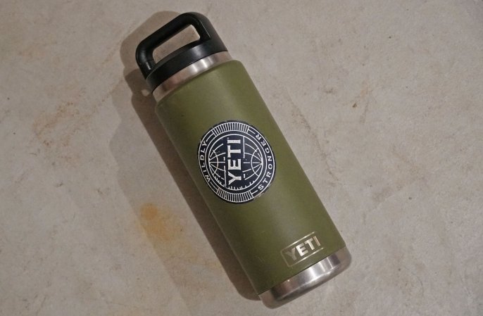  A green YETI Rambler thermos with a black cap