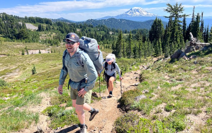 Two hikers walk up trail.