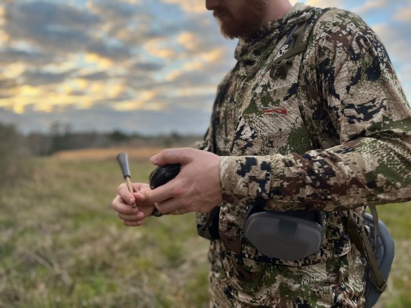 Turkey hunter using a slate turkey call