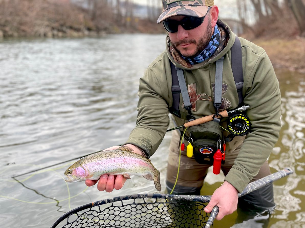 A man holding a fish on a river