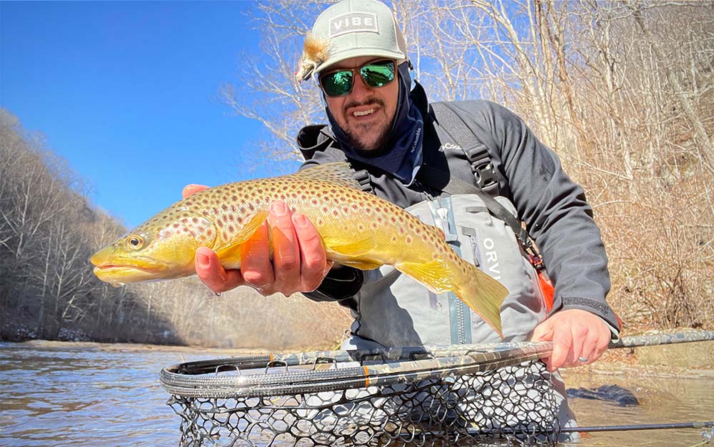 A man holding a fish in a river