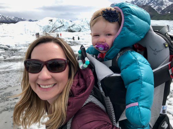 A woman carrying a toddler in a best baby carrier for hiking