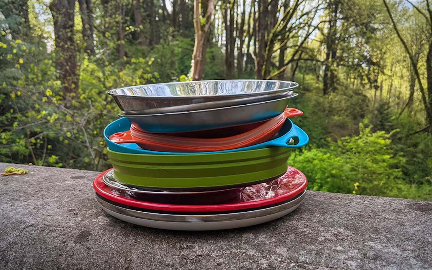 A set of plastic utensils. Dishes made of colorful plastic for picnic or  camping. A set of plates, mugs and cutlery for eating in nature. Stock  Photo