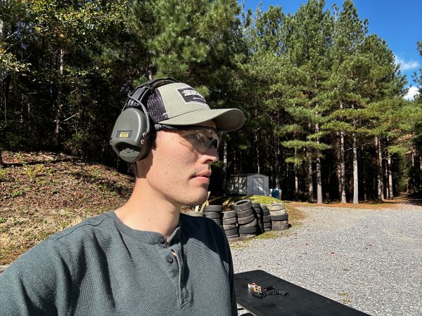 Man wears eye and ear protection at the gun range.