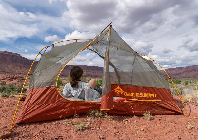 Woman lounging in a tent against a desert backdrop