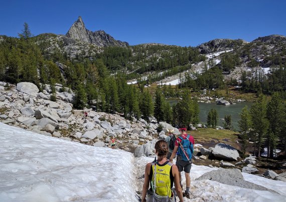 hikers heading across snow in a mountain setting