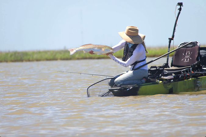 The author hold up a juvenile red fish.