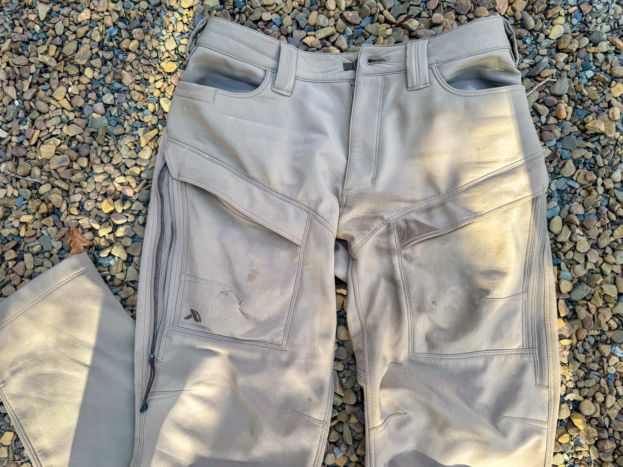 A pair of women's hunting pants on gravel.