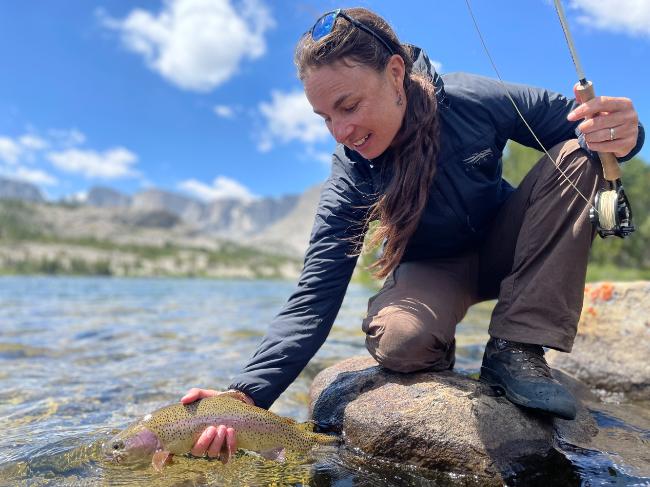 angler holds trout over water