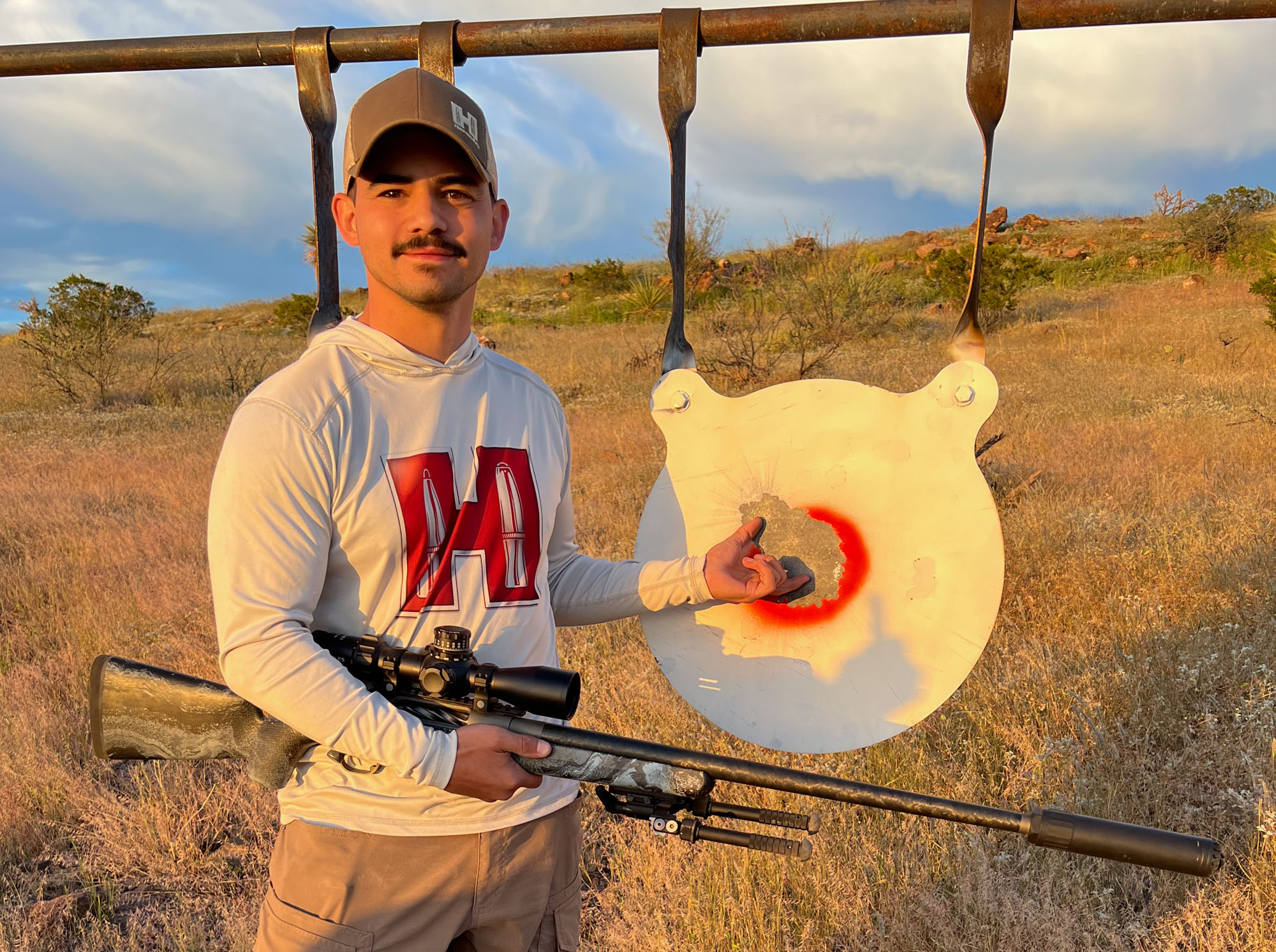 shooter with rifle showing off a group with the 7 PRC at 1000 yards