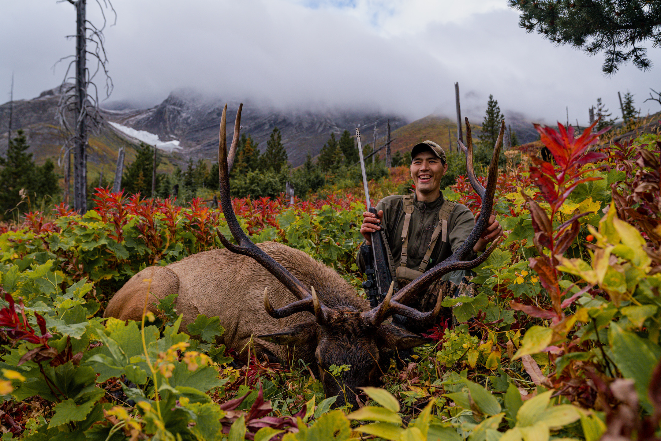 elk hunter poses with 6x6 bull in british columbia