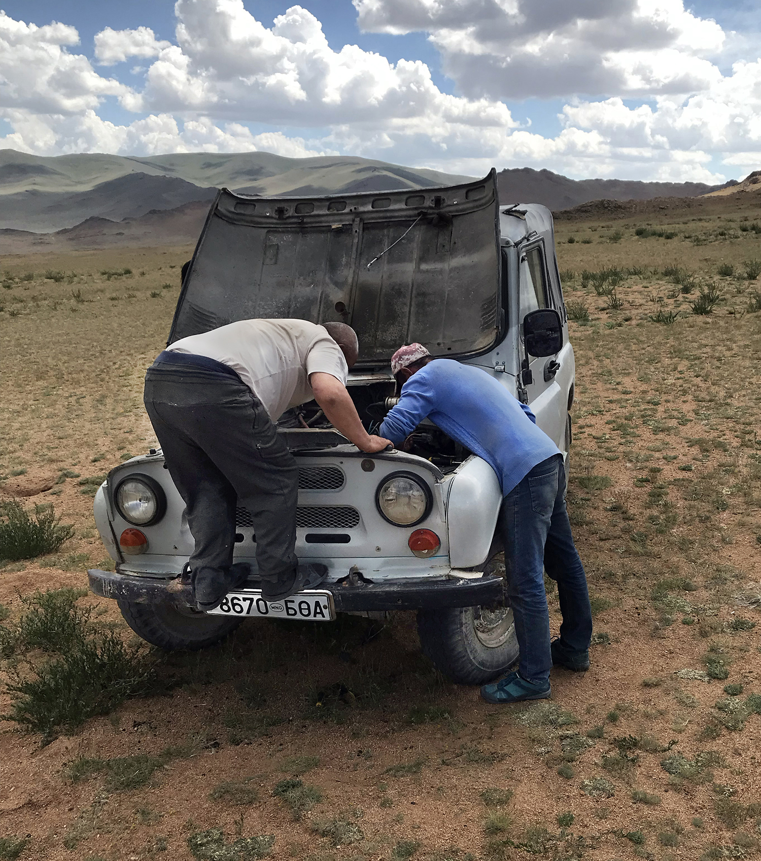 broken-down truck with open hood and two men