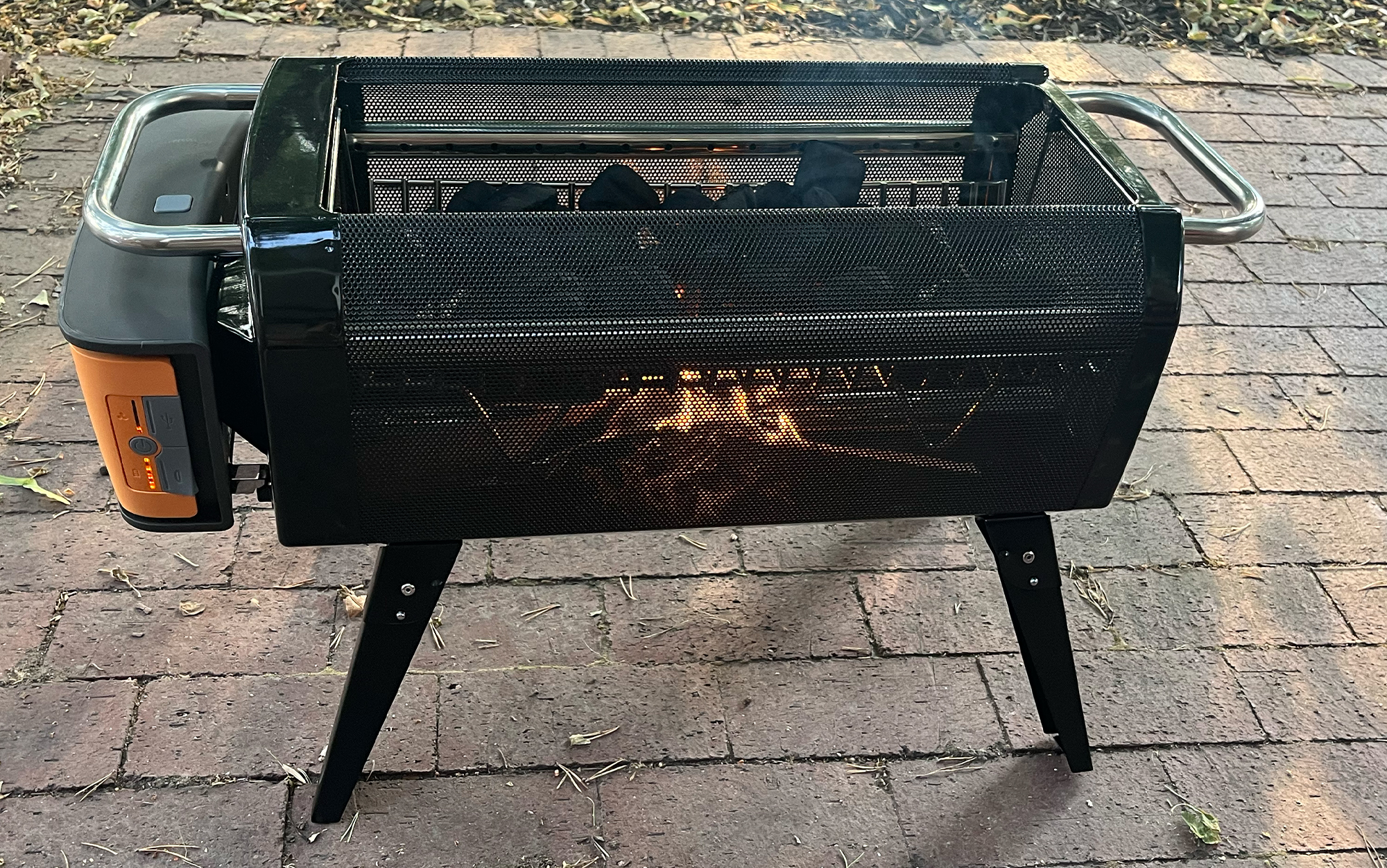 The small fire below lights the charcoal briquettes for grilling.