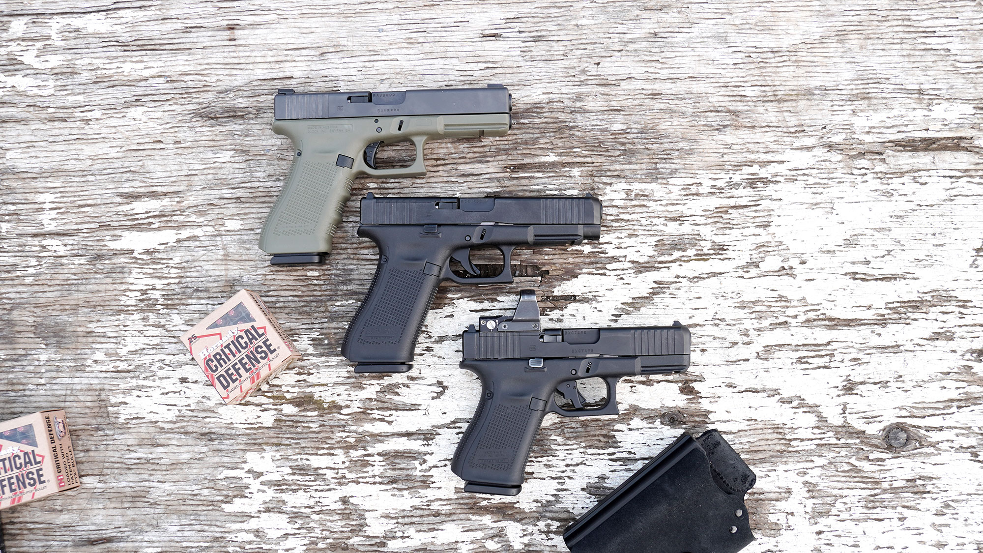 Glock 17, 47 and 19 stacked on a bench