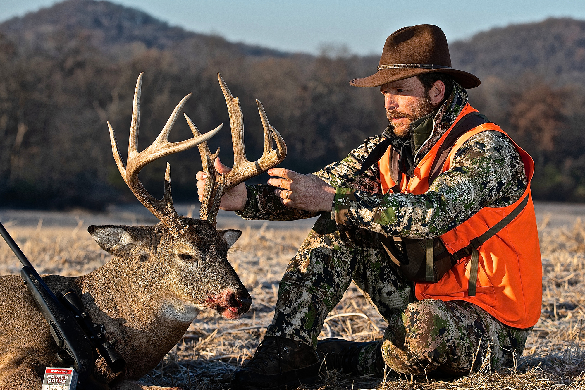 A hunter beside a big whitetail buck.