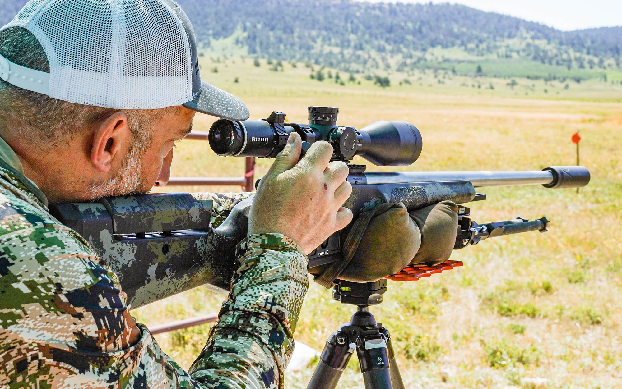 Snow looks through Riton long range rifle scope.