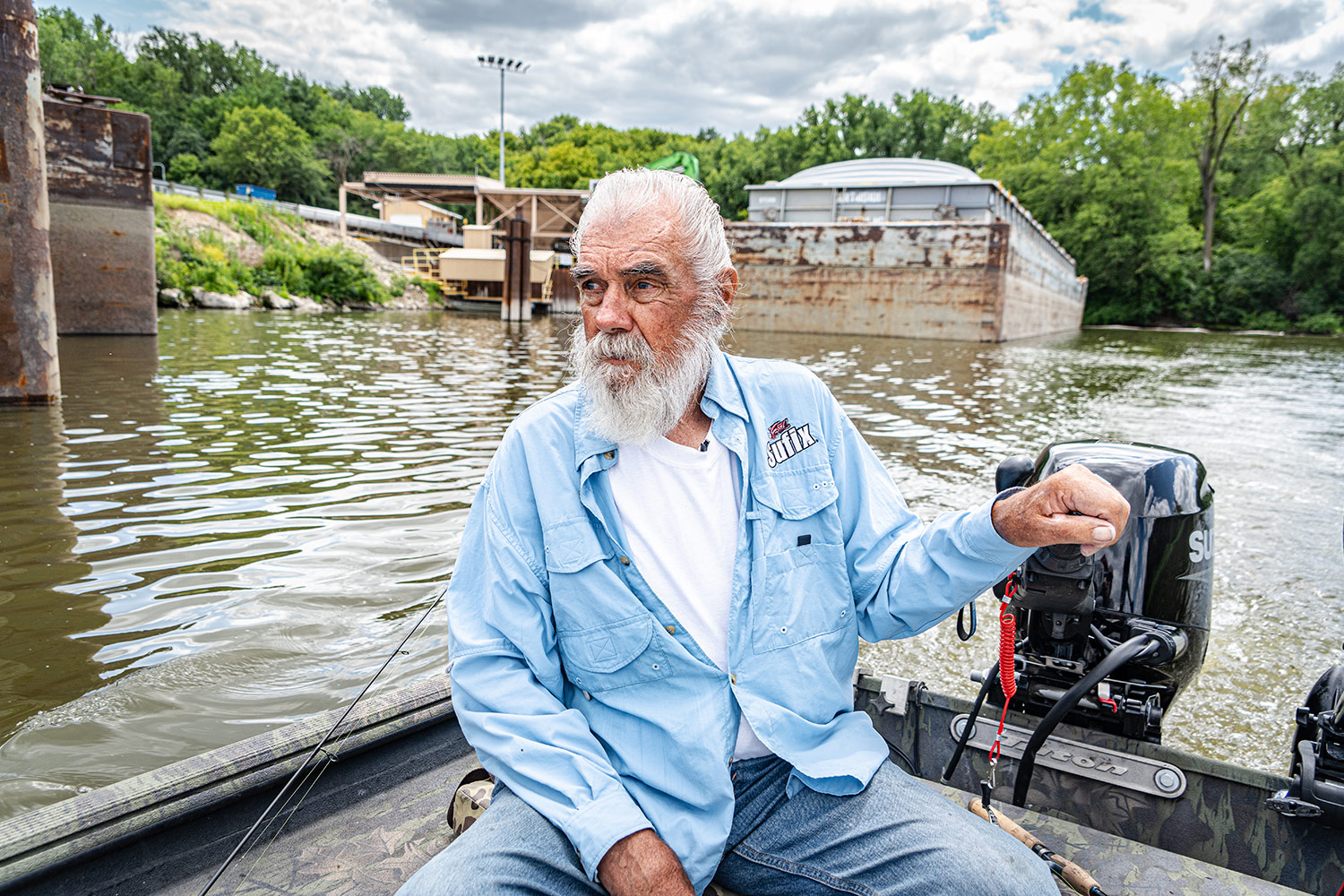 the griz sits in the stern of his boat to steer