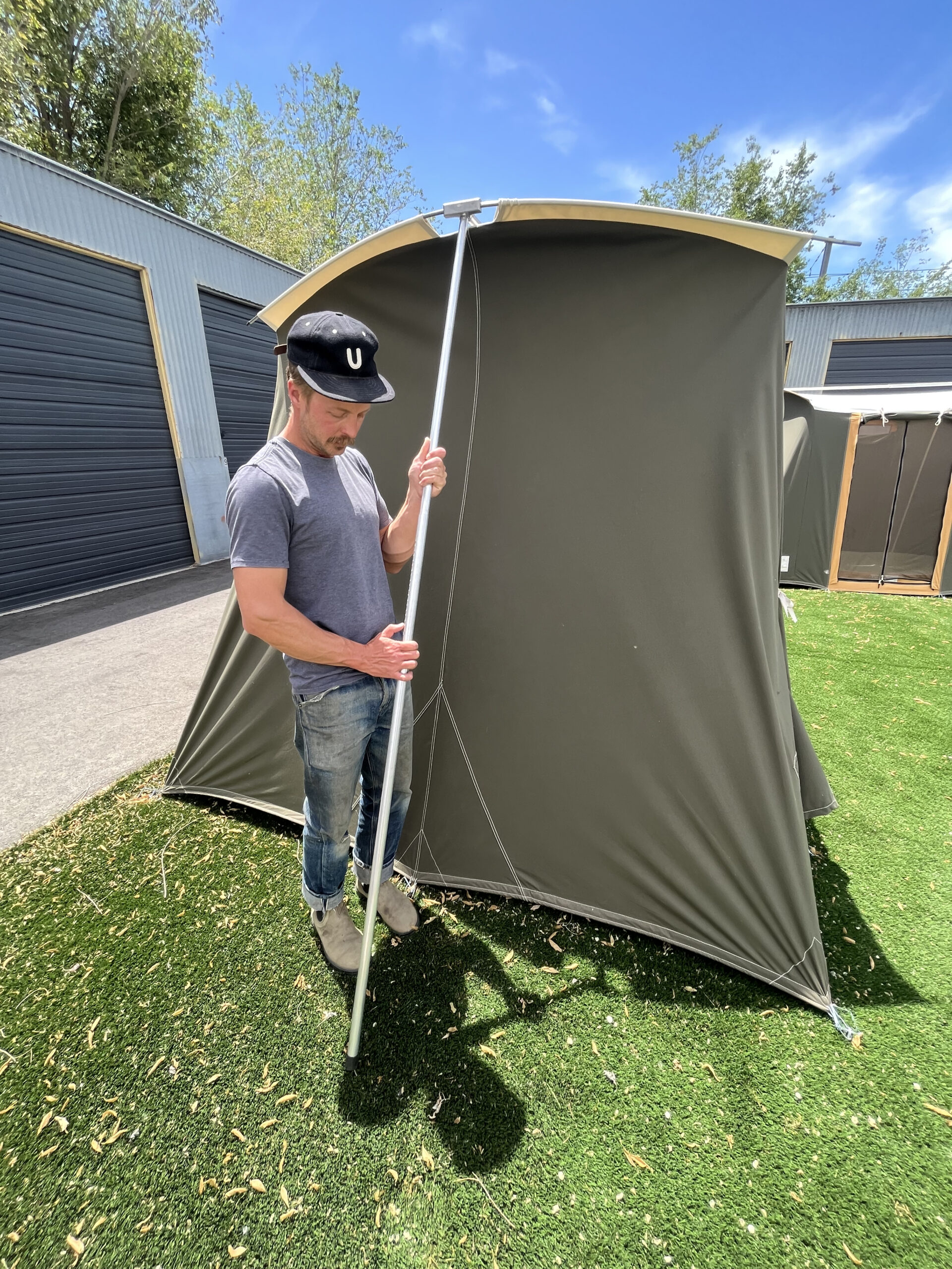 Man raises tent poles.