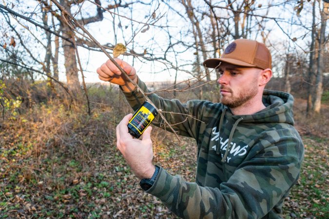 The author applies Ever Calm, one of the best deer attractants to a tree.